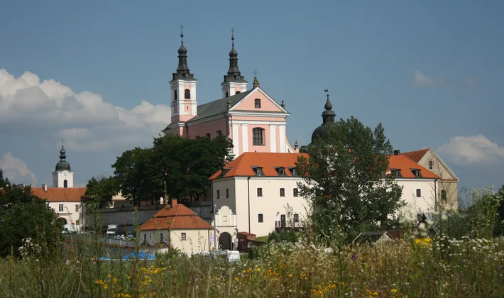 Vygrių kamaldulių vienuolynas su bažnyčios bokštais už pievos